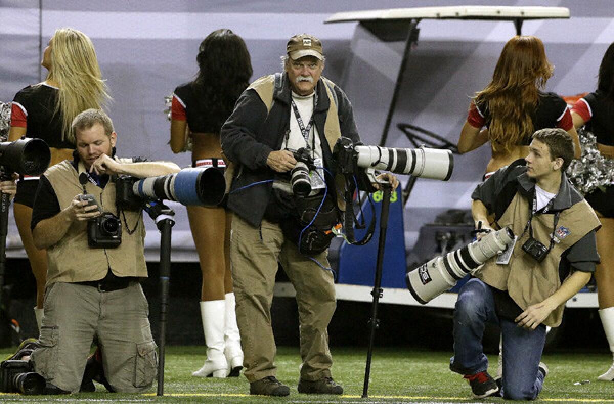 Dave Martin, standing, works an NFL game between the Carolina Panthers and the Atlanta Falcons.