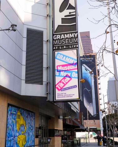 A sign hanging over a walkway on the Grammy Museum building