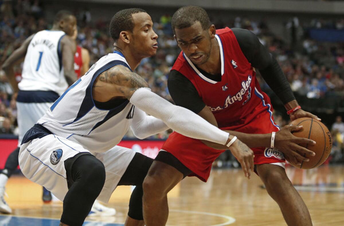 Clippers point guard Chris Paul protects the ball from the reach of Mavericks guard Monta Ellis during a game last week in Dallas.