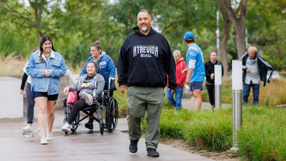 Richard Fierro and his family walk down a sidewalk 