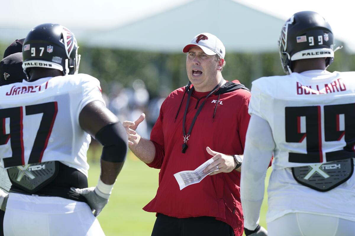 Atlanta Falcons head coach Arthur Smith talks to two players during practice.