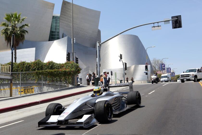 In this image released by Formula E Holdings, Lucas di Grassi drives a fully-electric Formula E race car past Disney Hall.