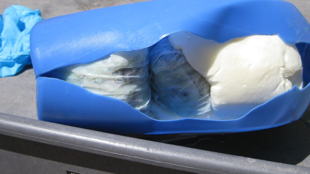Plastic laundry tub slit open to reveal bags of fentanyl