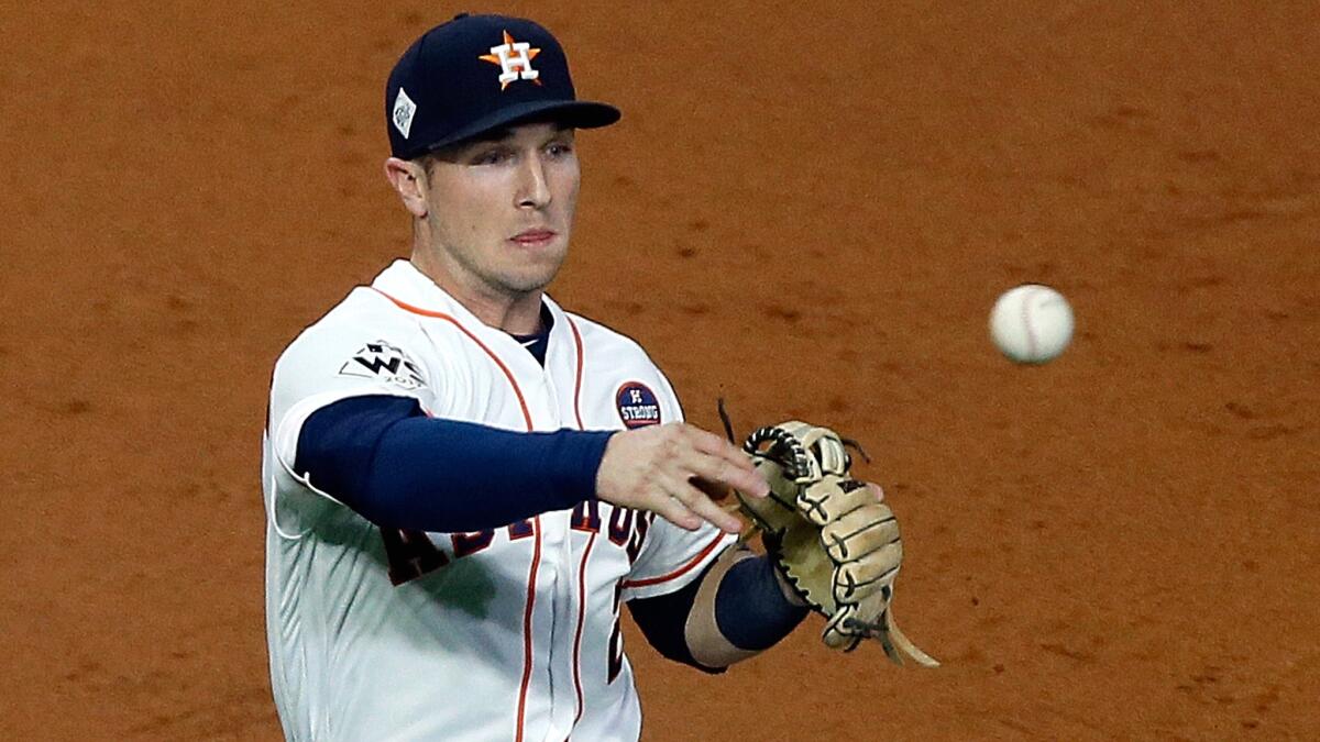 Astros third baseman Alex Bregman makes a throw to first base for an out during the third inning of Game 4.