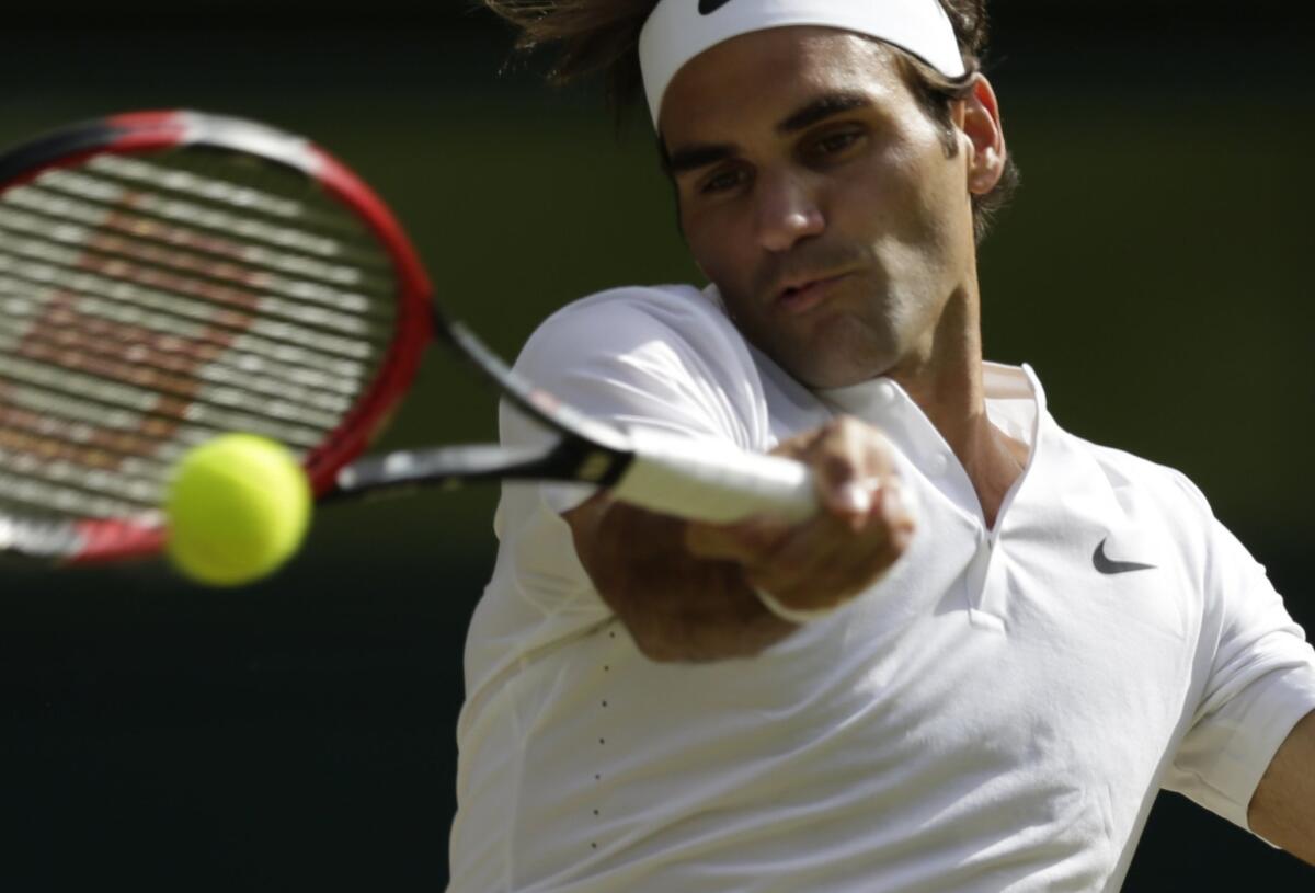 Roger Federer makes a return to Andy Murray during their men's singles semifinal match at Wimbledon on Friday.