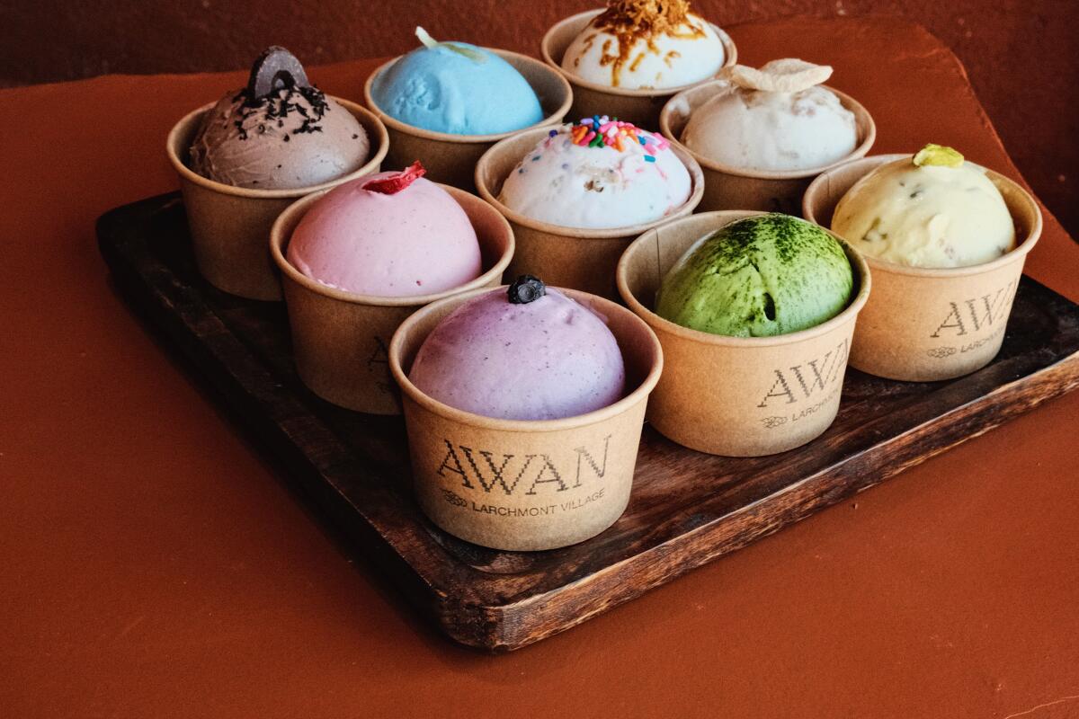 Nine small cups of Awan ice cream in various flavors against a rust-colored background.