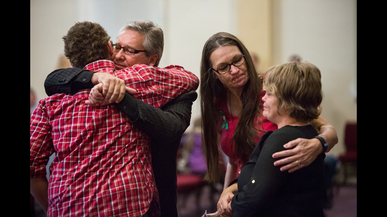 At the New Beginnings Church of God in Roseburg, Ore., on Oct. 4, Pastor Randy Scroggins hugs a survivor of the Umpqua Community College mass shooting.