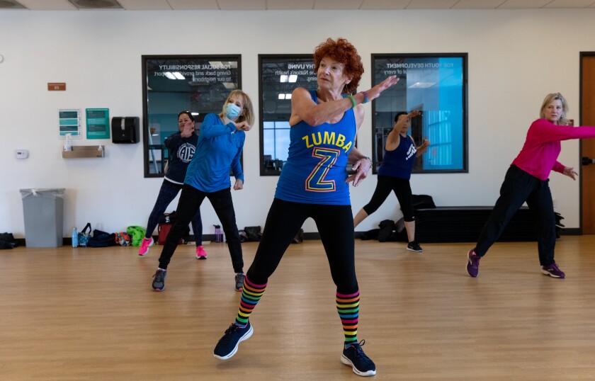 Adair Roche, 73, center, and about a dozen people participate in a Zumba class at Border View Family YMCA in San Diego.