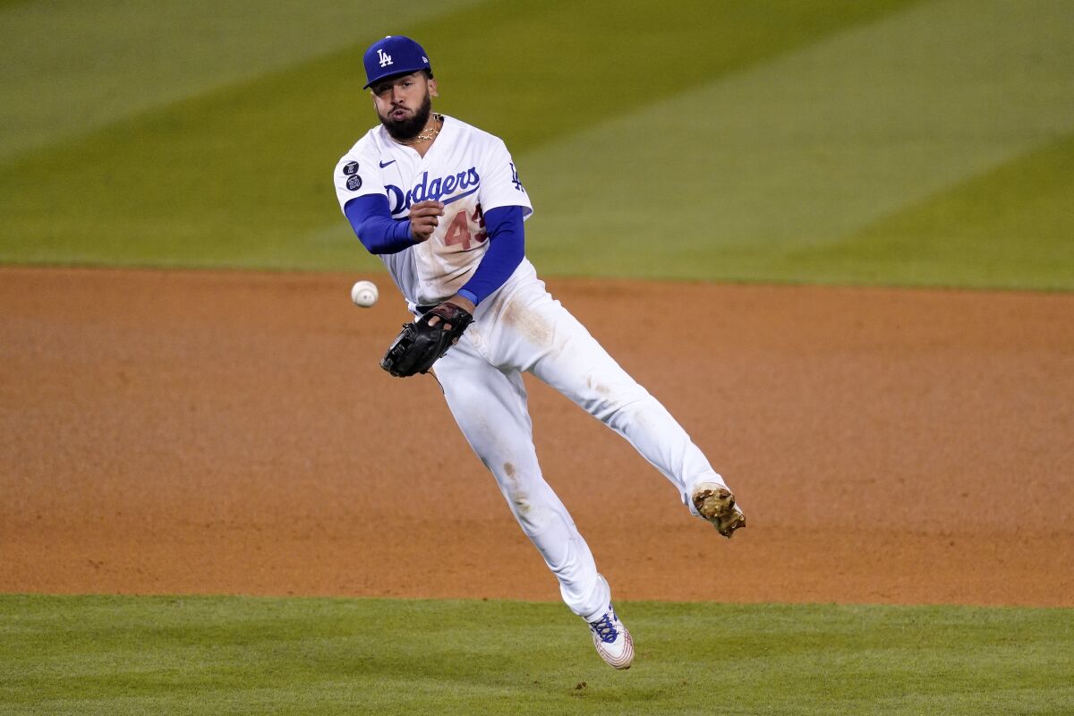 Los Angeles Dodgers third baseman Edwin Rios throws out Cincinnati Reds' Tucker Barnhart at first during the ninth inning of a baseball game Monday, April 26, 2021, in Los Angeles. (AP Photo/Mark J. Terrill)