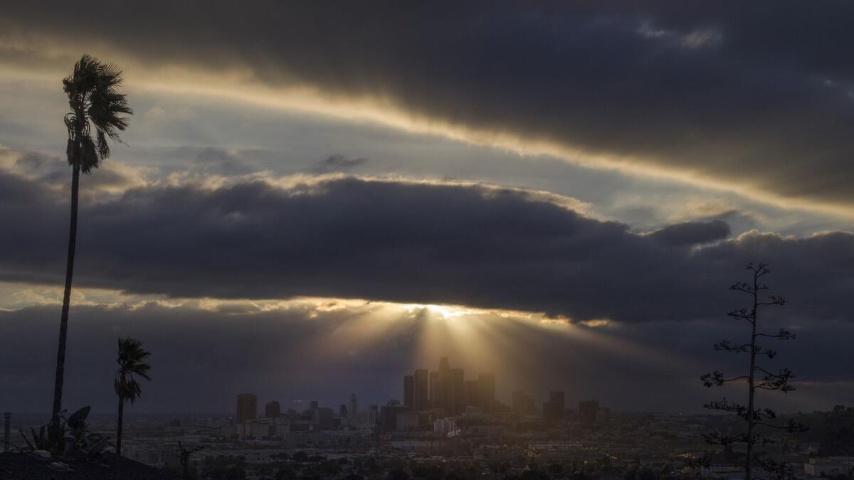 A storm settles over downtown Los Angeles in 2017. An atmospheric river that could wreak havoc by unleashing floods and landslides is set to arrive in Southern California on Tuesday night.
