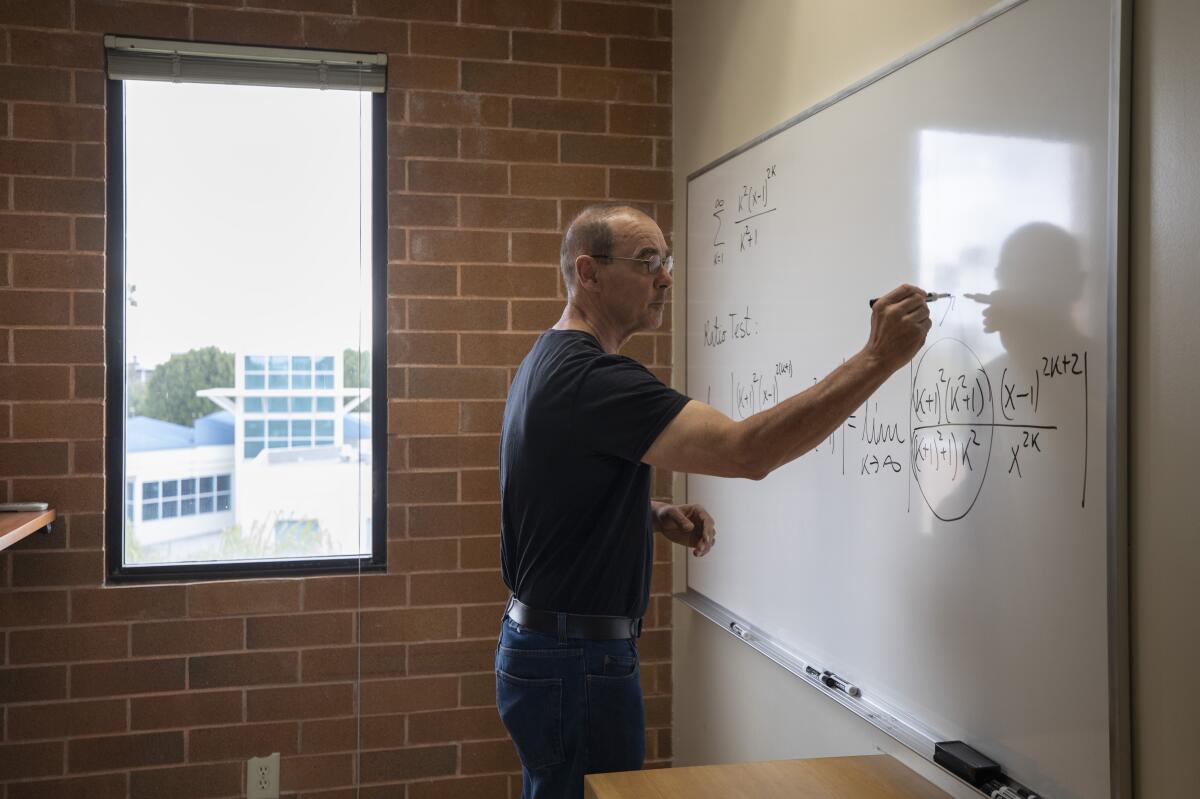 Math professor Michael Neubauer writes on a whiteboard