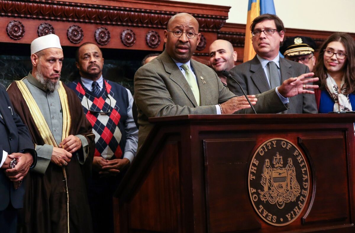 Mayor Michael Nutter, center front, joins with interfaith leaders to speak to the media on Tuesday, Dec. 8, 2015, in Philadelphia. Philadelphia police will step up patrols around worship sites as they look for the person who left a severed pig's head outside the Al Aqsa Islamic Society. (Steven M. Falk/The Philadelphia Inquirer via AP) PHIX OUT; TV OUT; MAGS OUT; NEWARK OUT; MANDATORY CREDIT