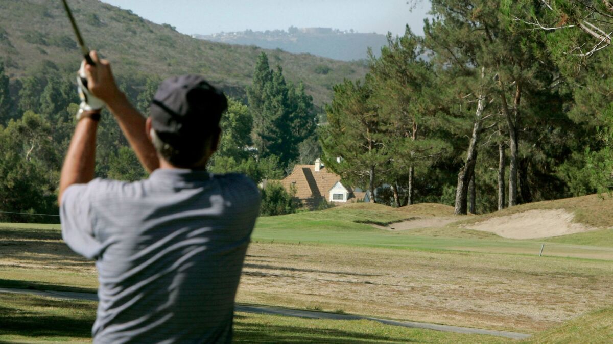 A golfer tees off on a hole at Carmel Mountain Ranch Country Club golf course.
