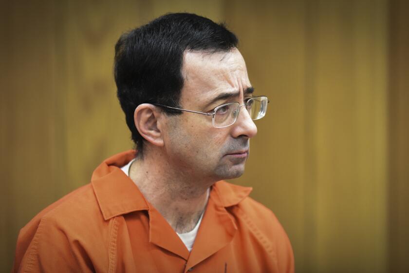 FILE - In this Feb. 5, 2018 file photo, Larry Nassar, former sports doctor who admitted molesting some of the nation's top gymnasts, appears in Eaton County Court in Charlotte, Mich. A spokeswoman said Tuesday, Dec. 24, 2019 that Michigan Attorney General Dana Nessel has suspended a nearly two-year-long investigation into Michigan State University's handling of complaints against now-imprisoned serial sexual abuser Larry Nassar. It is unclear if or when the investigation will resume. (Matthew Dae Smith/Lansing State Journal via AP, File)