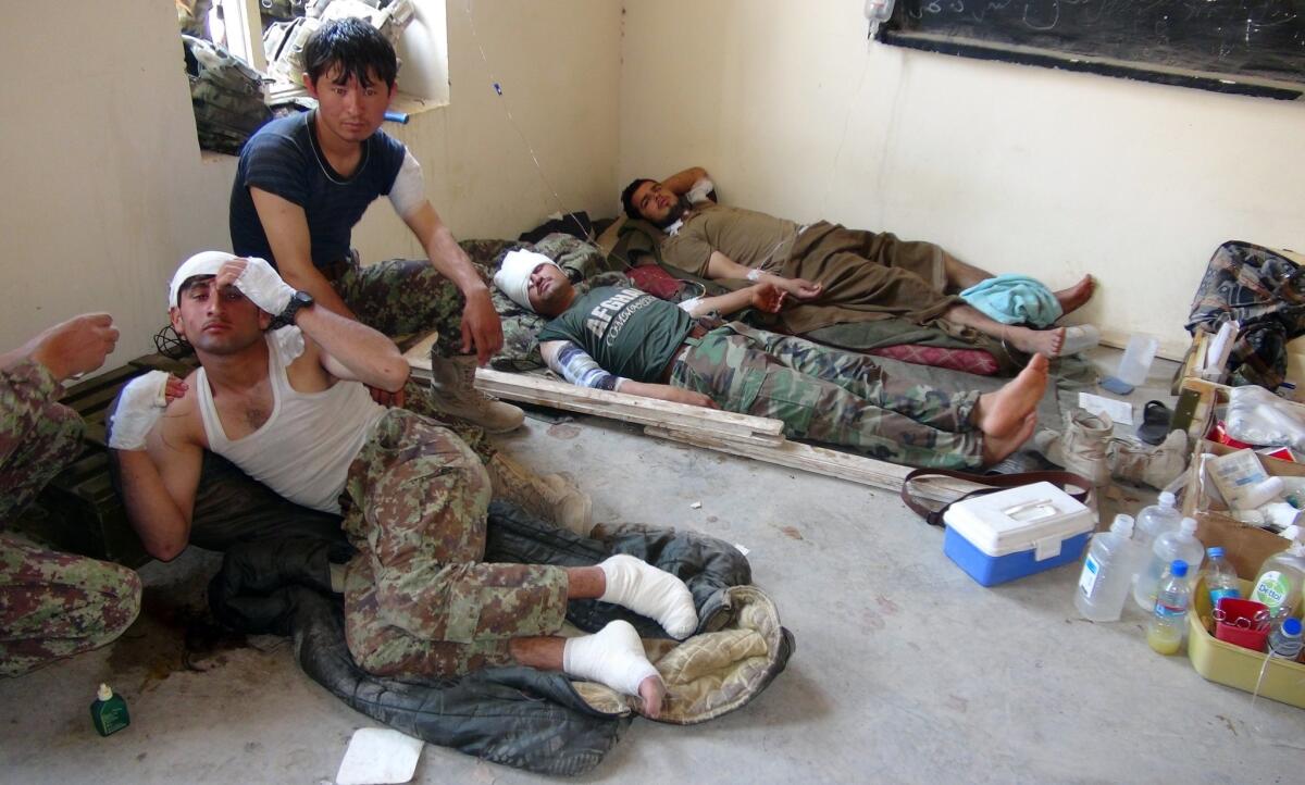Wounded Afghan soldiers lie on the ground as they receive treatment in Logar province on Monday after what Afghan officials said was a U.S. airstrike on the troops' base.