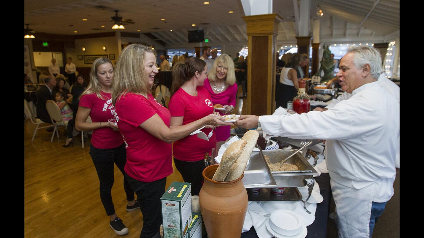 Janet Norman is handed a bowl of farrotto porcini by il Farro owner Domenico Maurici during the Newport Beach Taste of History, celebrating Newport Beach Historical Society's 50th anniversary on Friday at Balboa Pavilion in Newport Beach.