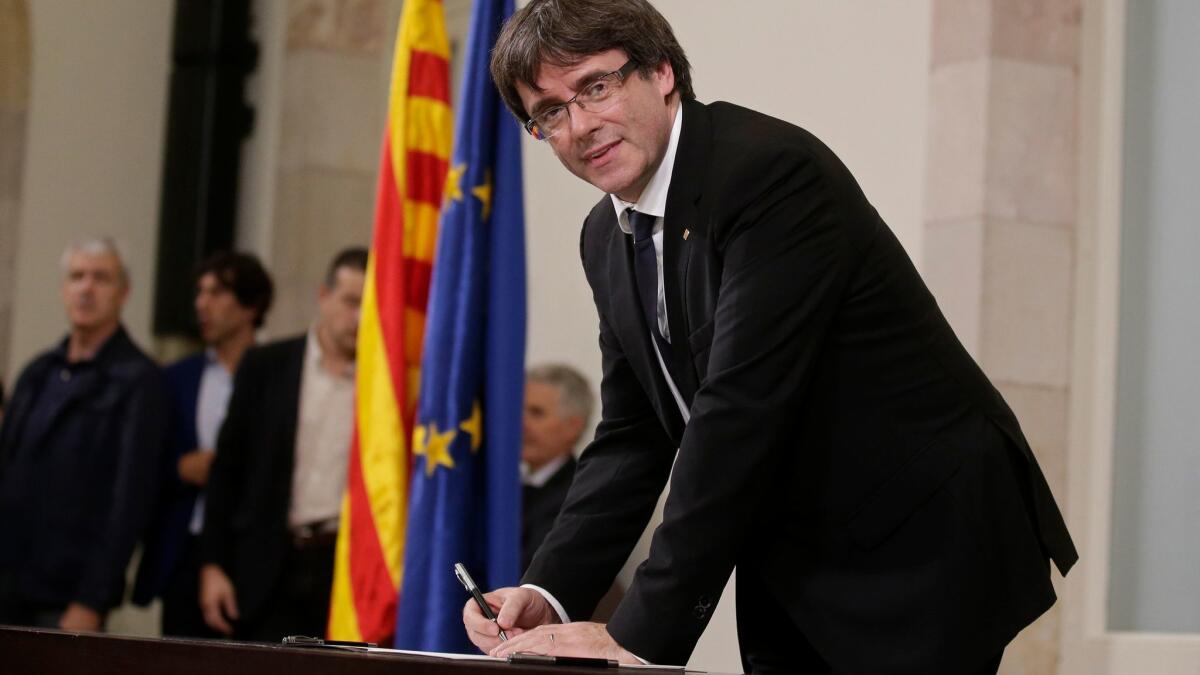 Catalonia regional President Carles Puigdemont signs an independence declaration document after a parliamentary session in Barcelona, Spain, on Oct. 10, 2017.