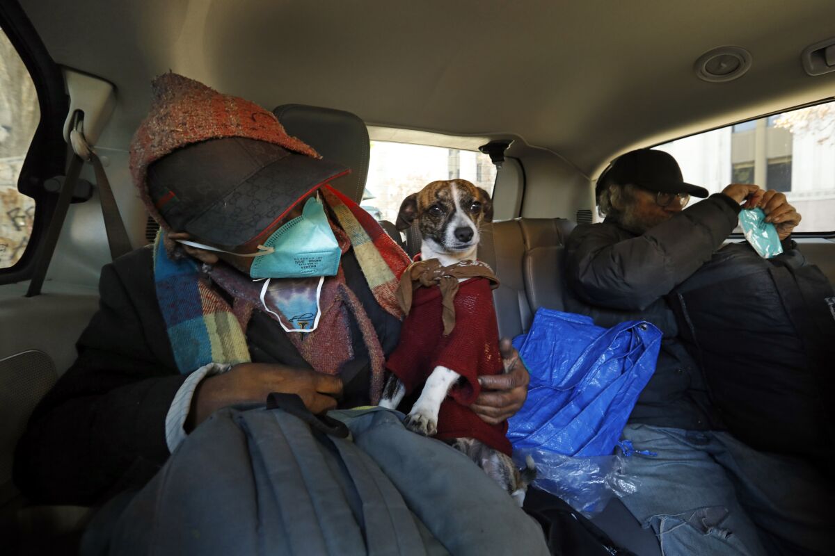 Candelario Cortez et son chien, Rocky, dans une camionnette les déplaçant d'un campement près de l'hôtel de ville de Los Angeles.