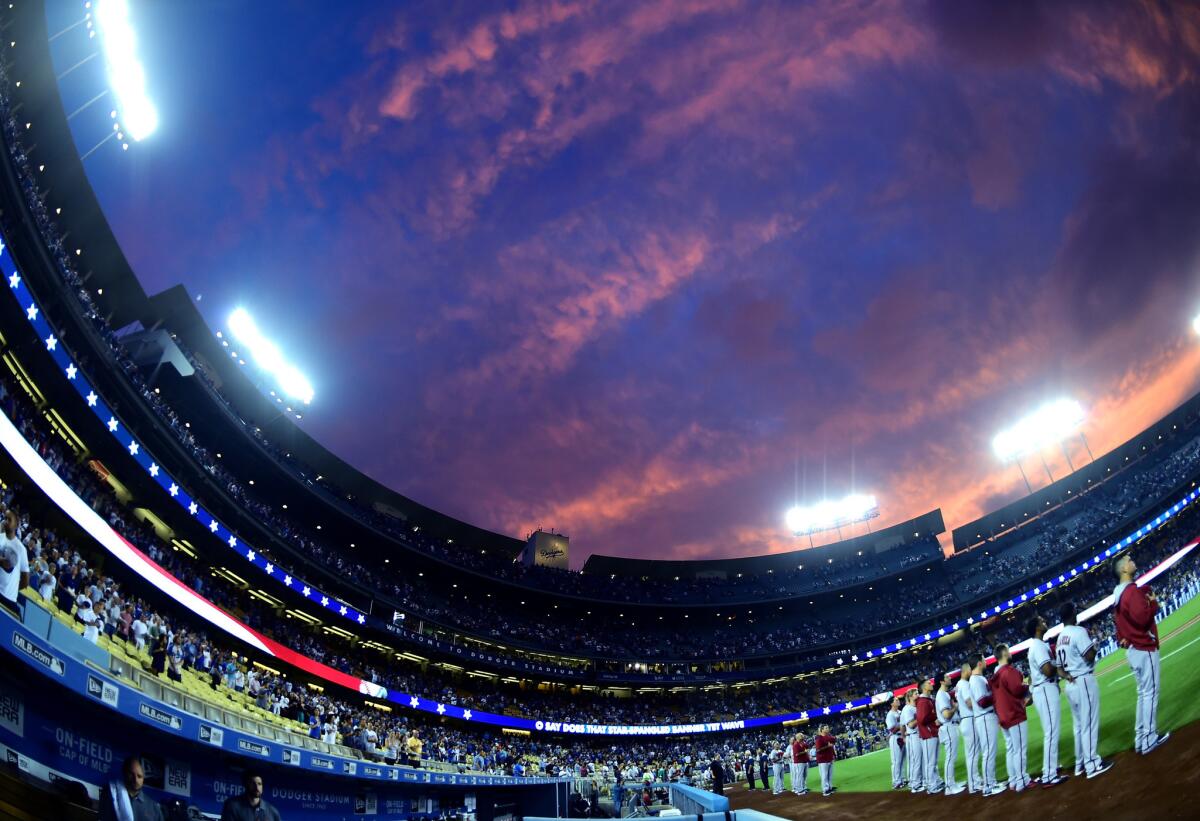 The Diamondbacks line up for the National Anthem during a sunset before a game against the Dodgers at Dodger Stadium.