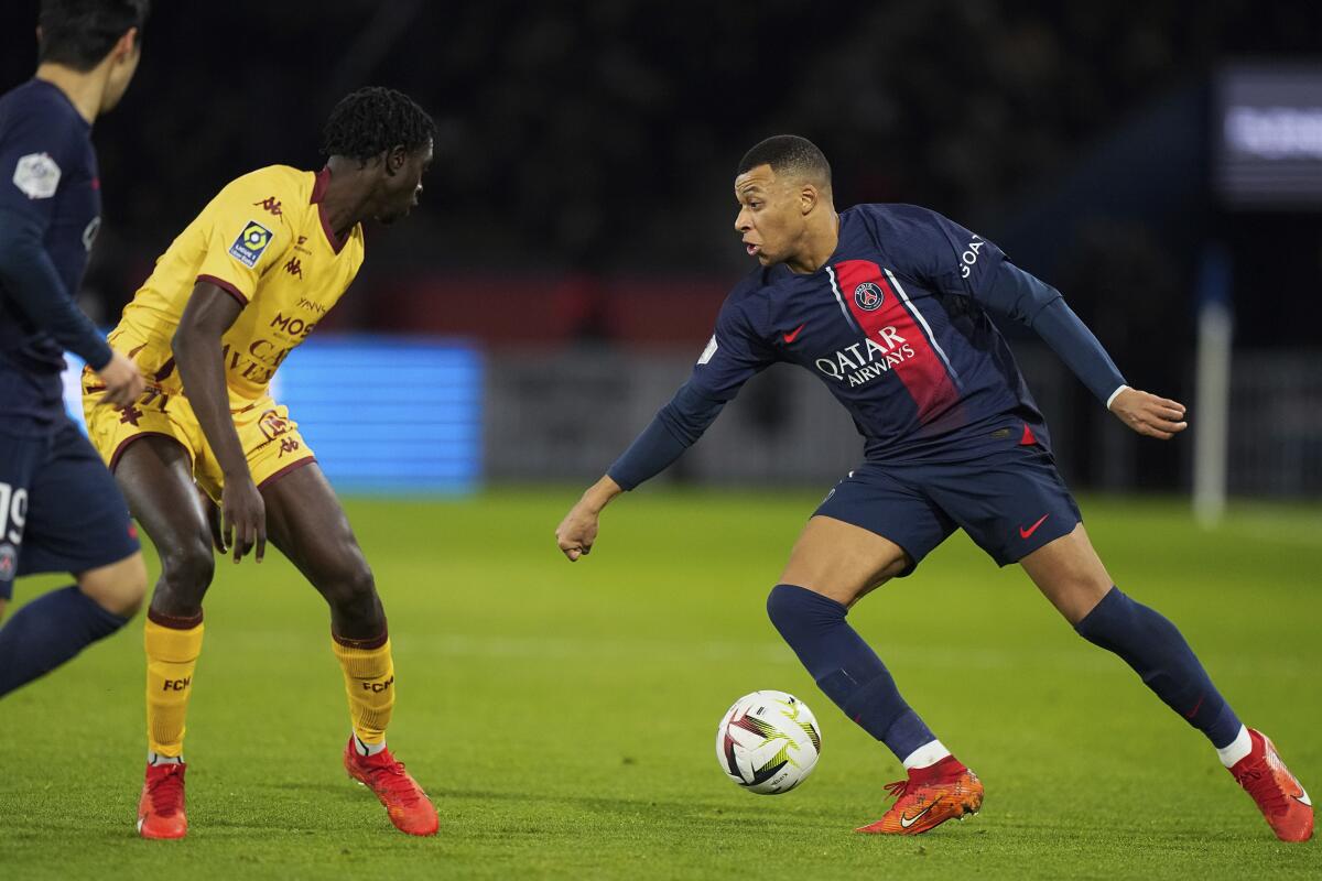 Kylian Mbappé, del París Saint-Germain, controla el balón frente a Joseph N'Duquidi, de Metz, 