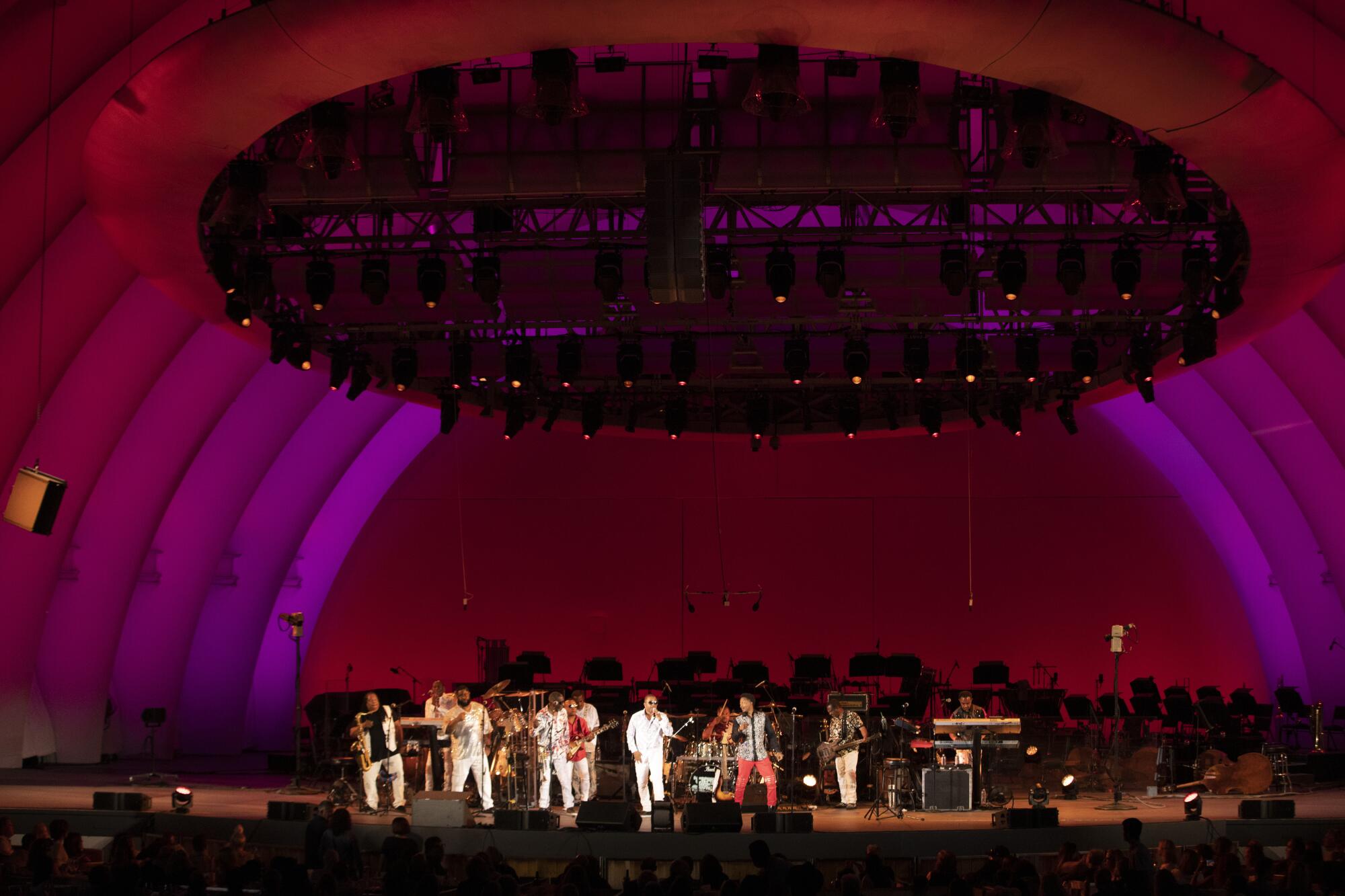 The Bowl stage, seen from a distance, glows purple and red as a band performs.