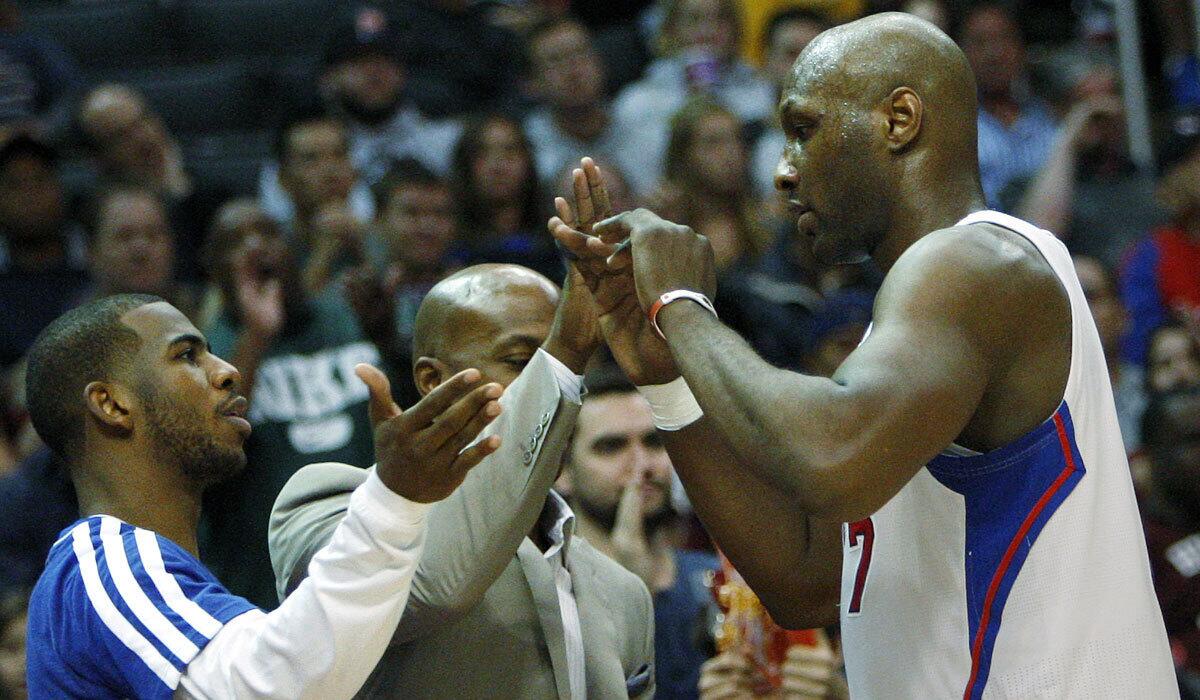 Lamar Odom, right, gets high-fives from Clippers teammates Chris Paul, left, and Chauncey Billups on Dec. 8, 2012.