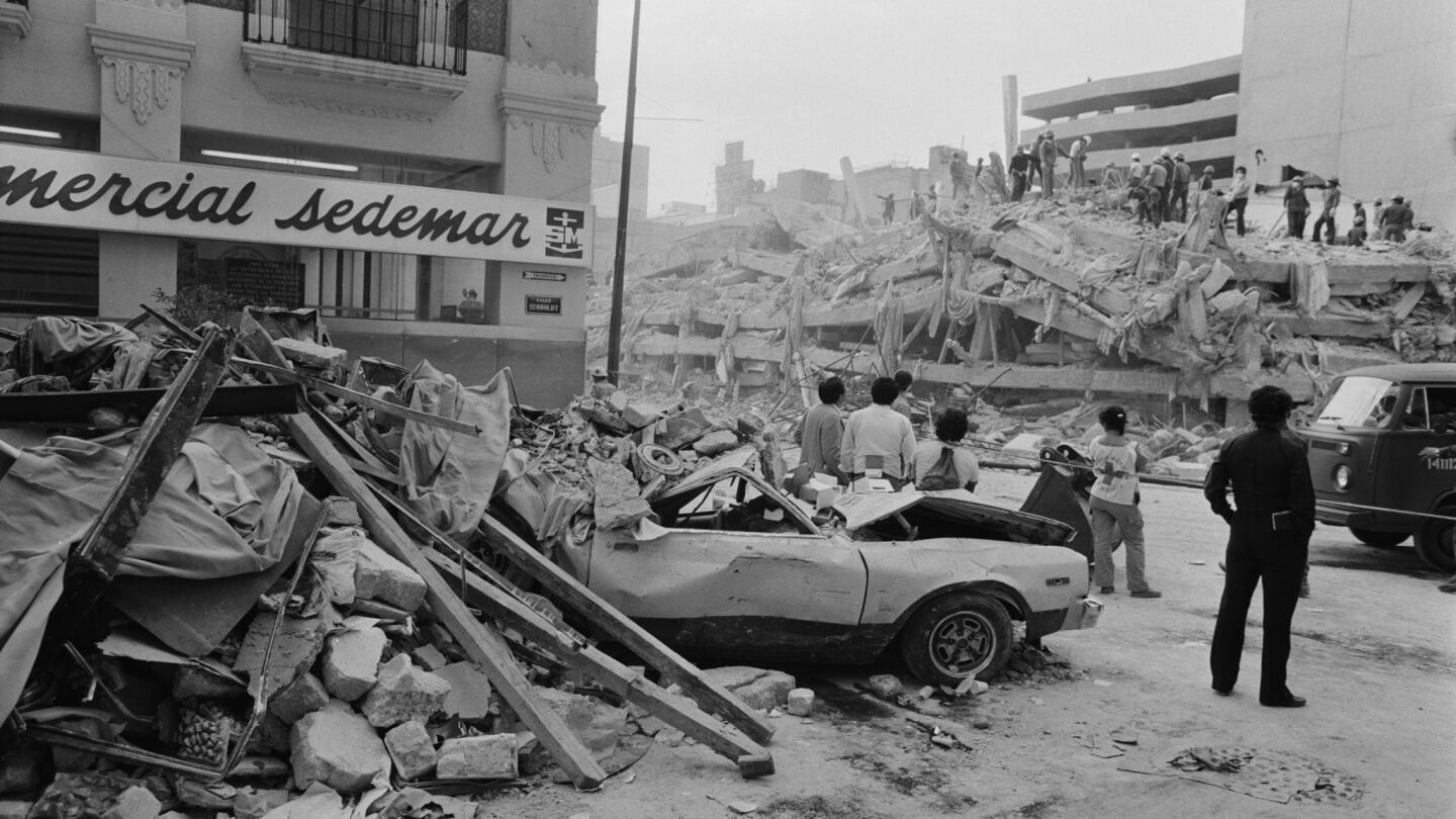 People watch rescue workers after the 1985 quake.