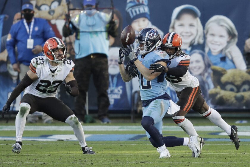 Tennessee Titans wide receiver Adam Humphries (10) loses control of the ball as he is hit by Cleveland Browns cornerback Terrance Mitchell (39) in the second half of an NFL football game Sunday, Dec. 6, 2020, in Nashville, Tenn. The Browns intercepted the ball on the play. (AP Photo/Ben Margot)