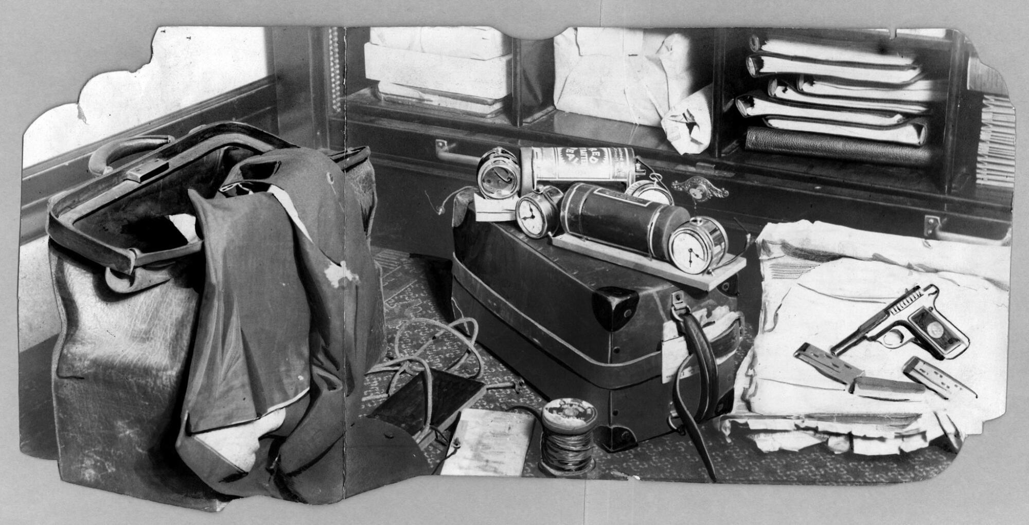 A black-and-white photograph of a leather bag alongside wires and other supplies that can be used to make bombs