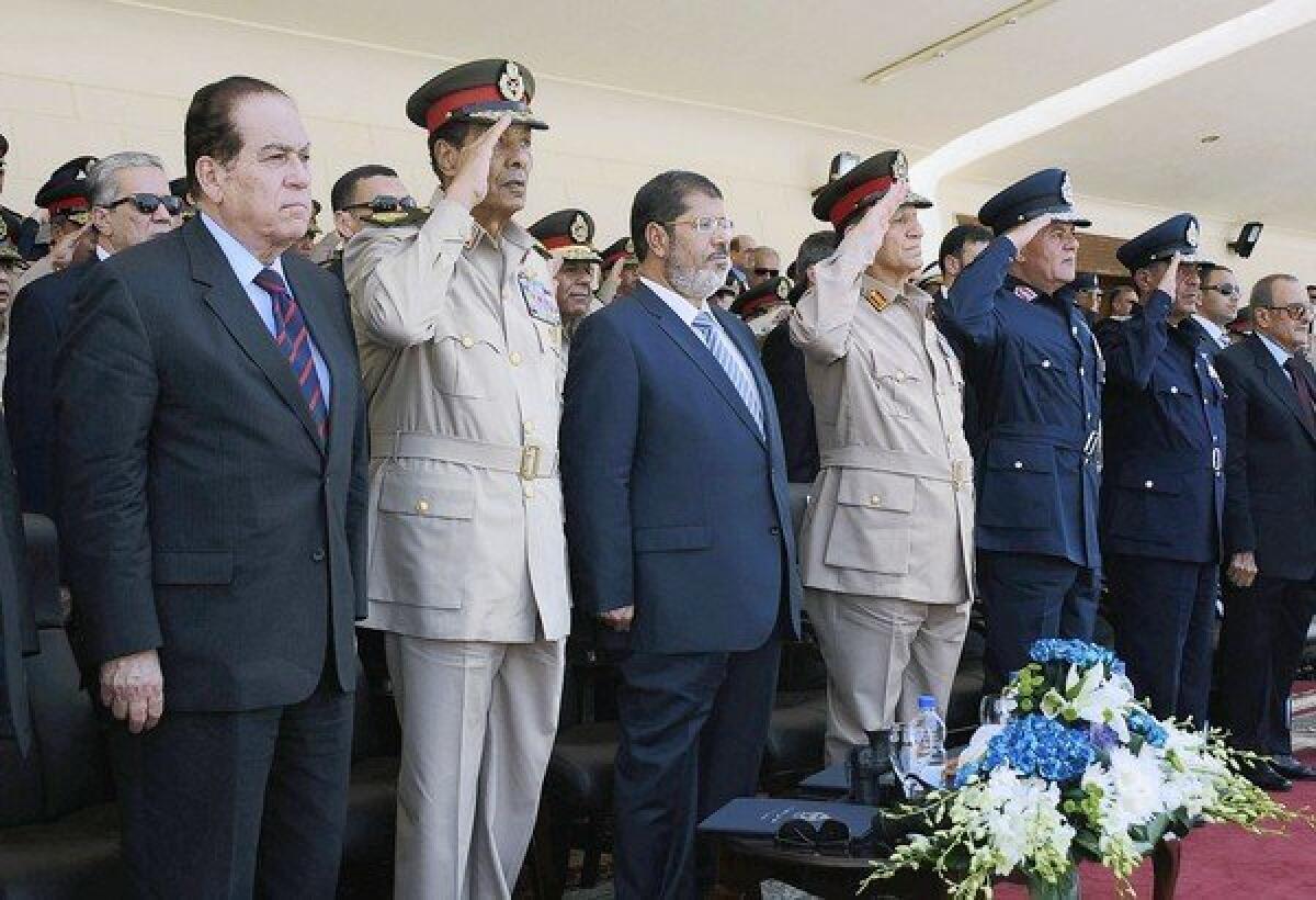 In a July ceremony at an air force base in Cairo, Egyptian President Mohamed Morsi is flanked by Field Marshal Mohamed Hussein Tantawi, left, and Lt. Gen. Sami Anan. Morsi has since dismissed Tantawi as defense minister and military commander and Anan as military chief of staff.