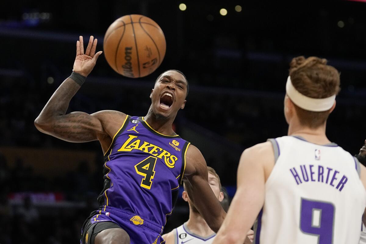 Lakers guard Lonnie Walker IV reacts after dunking in front of Sacramento Kings guard Kevin Huerter.