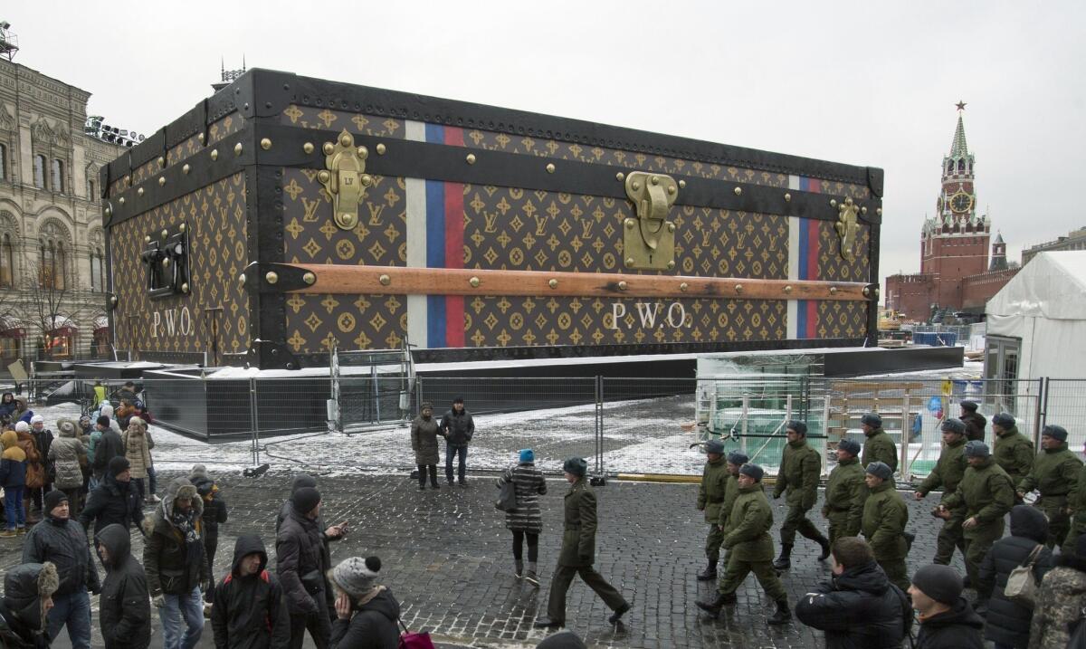 Tourists and visitors pass by a two-story Louis Vuitton suitcase erected in Red Square in Moscow last week.