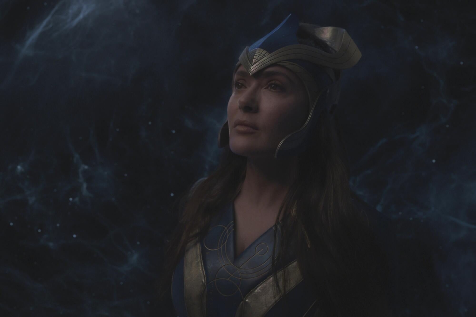 A woman in a blue superhero suit and headpiece.