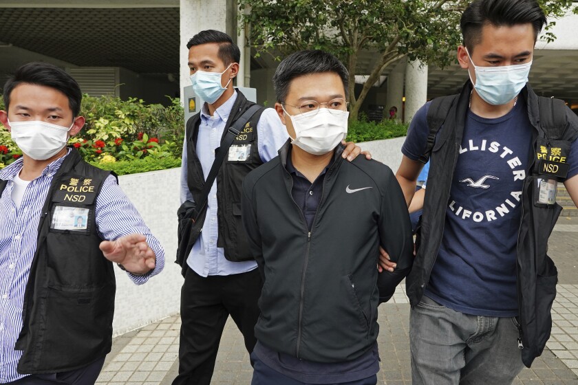 Ryan Law, second from right, Apple Daily's chief editor, is arrested by police officers in Hong Kong Thursday, June 17, 2021. Hong Kong police on Thursday morning arrested the chief editor and four other senior executives of Apple Daily under the national security law on suspicion of collusion with a foreign country to endanger national security, according to local media reports. Local media, including the South China Morning Post and Apple Daily, reported Thursday that national security police arrested Apple Daily's chief editor Ryan Law. (AP Photo)