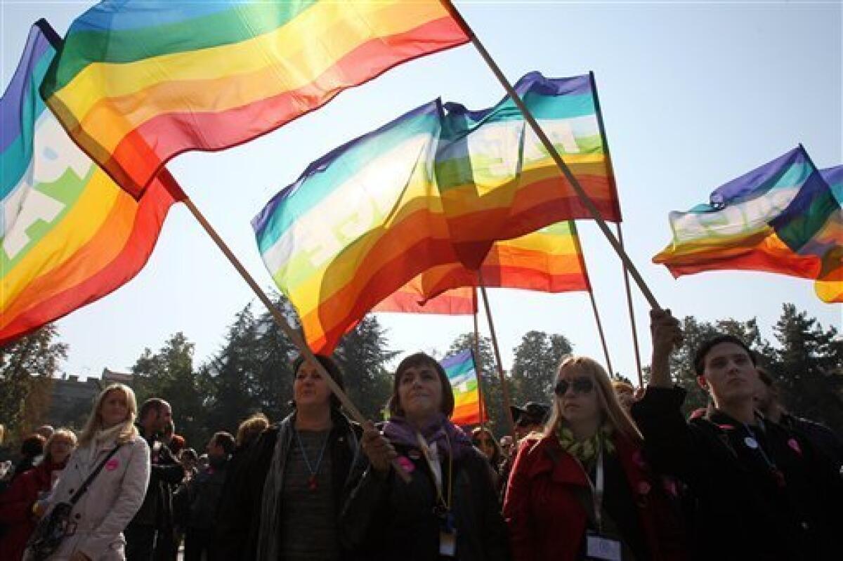 People wave peace flags at the gay parade in Belgrade, Serbia, Sunday, Oct. 10, 2010. Riot police in Serbia clashed with some hundreds of far-right protesters who tried to disrupt the gay pride march in Belgrade on Sunday, with more than a dozen people reported injured, officials said.(AP Photo/Darko Vojinovic)