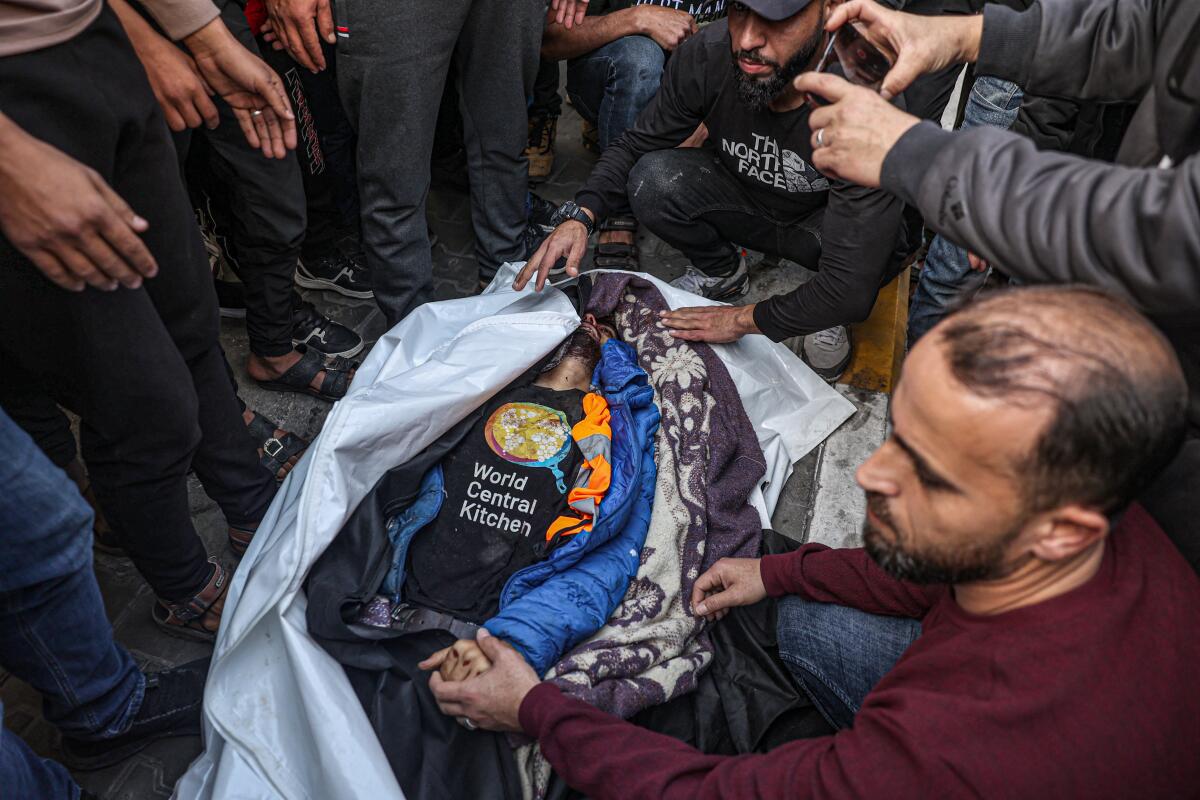 Relatives and friends mourn by the body of Saif abu Taha, a staff member of World Central Kitchen.