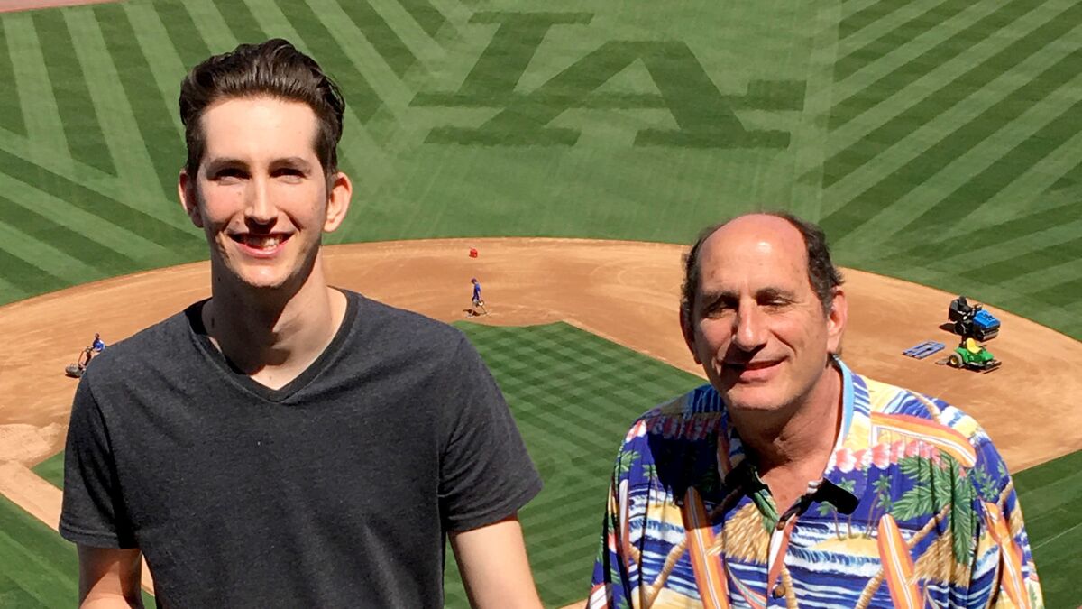 Michael Zalin, left, and his father, Bill, pose for a photo in the upper deck of Dodger Stadium, where they make an annual visit before the season begins for lunch.