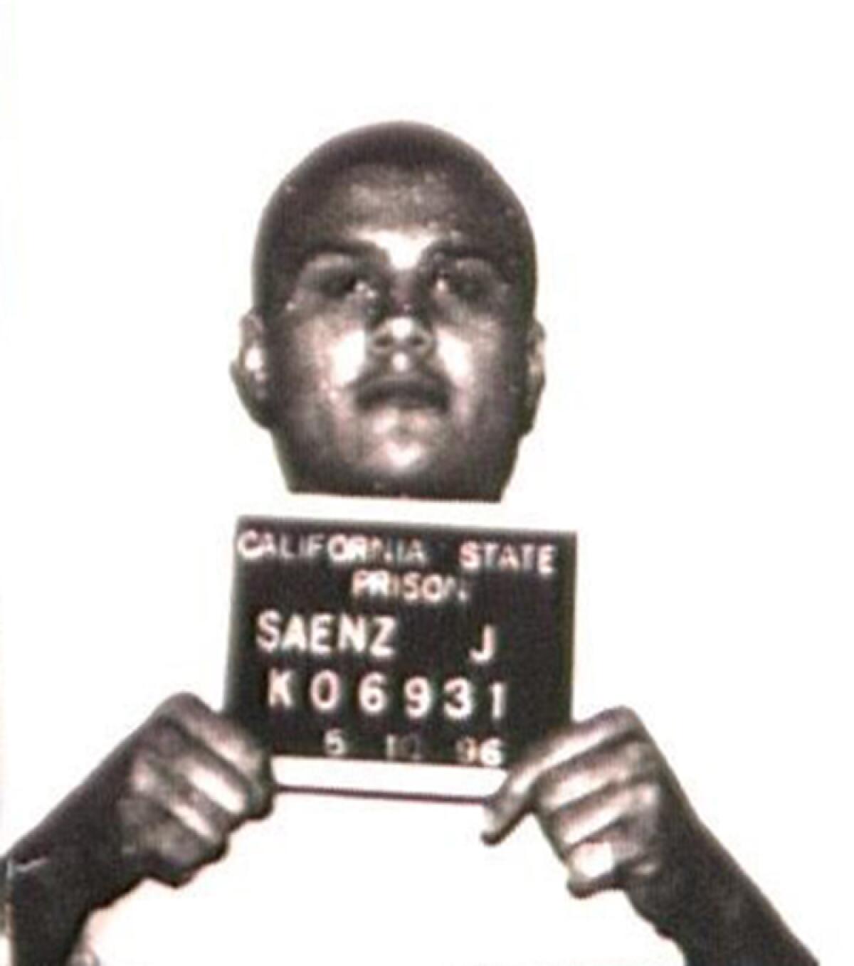 A black-and-white mugshot of Jose Saenz holding up his California State Prison identification number