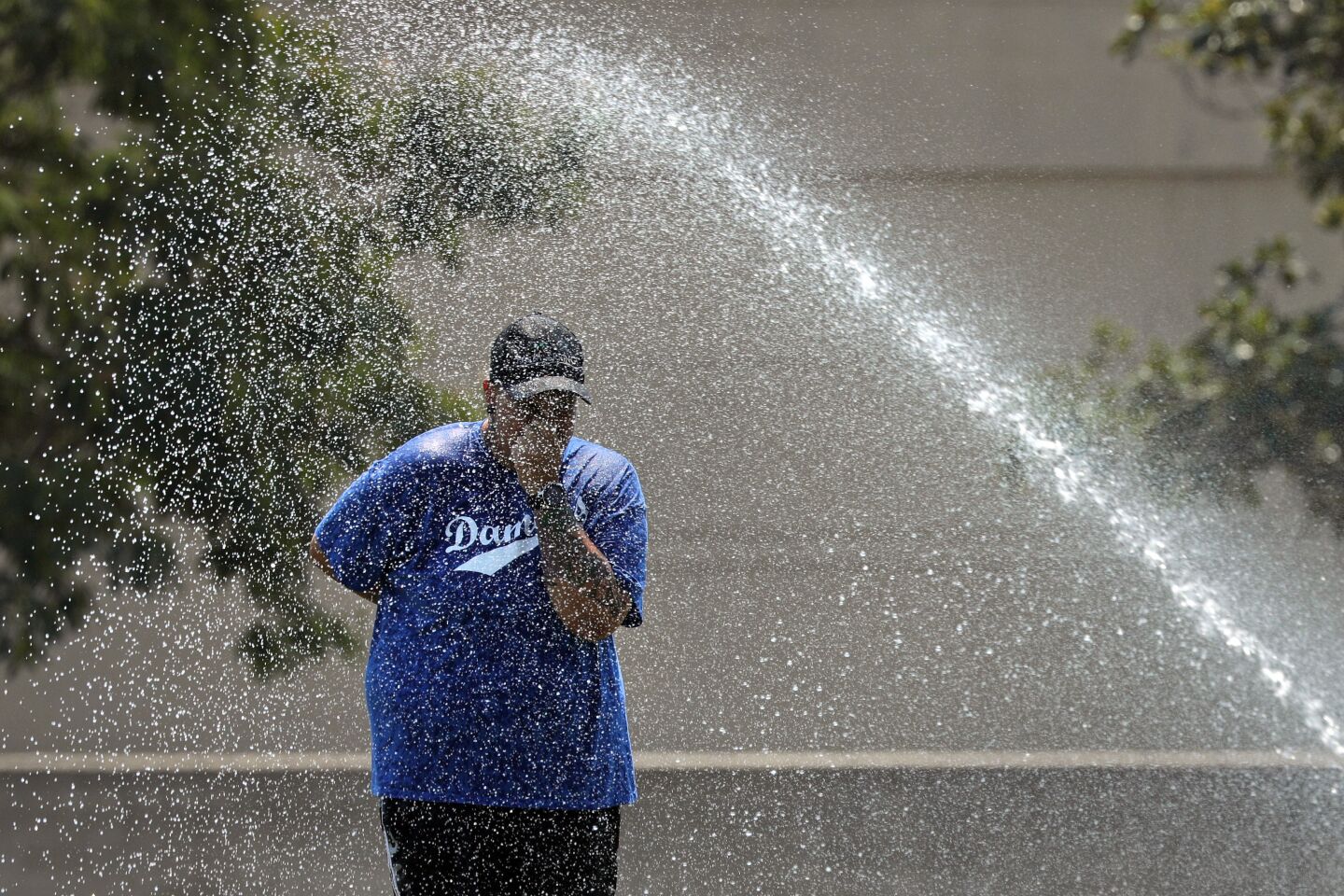 Reana Gallardo cools off in the sprinkler at Mason Park in Chatsworth