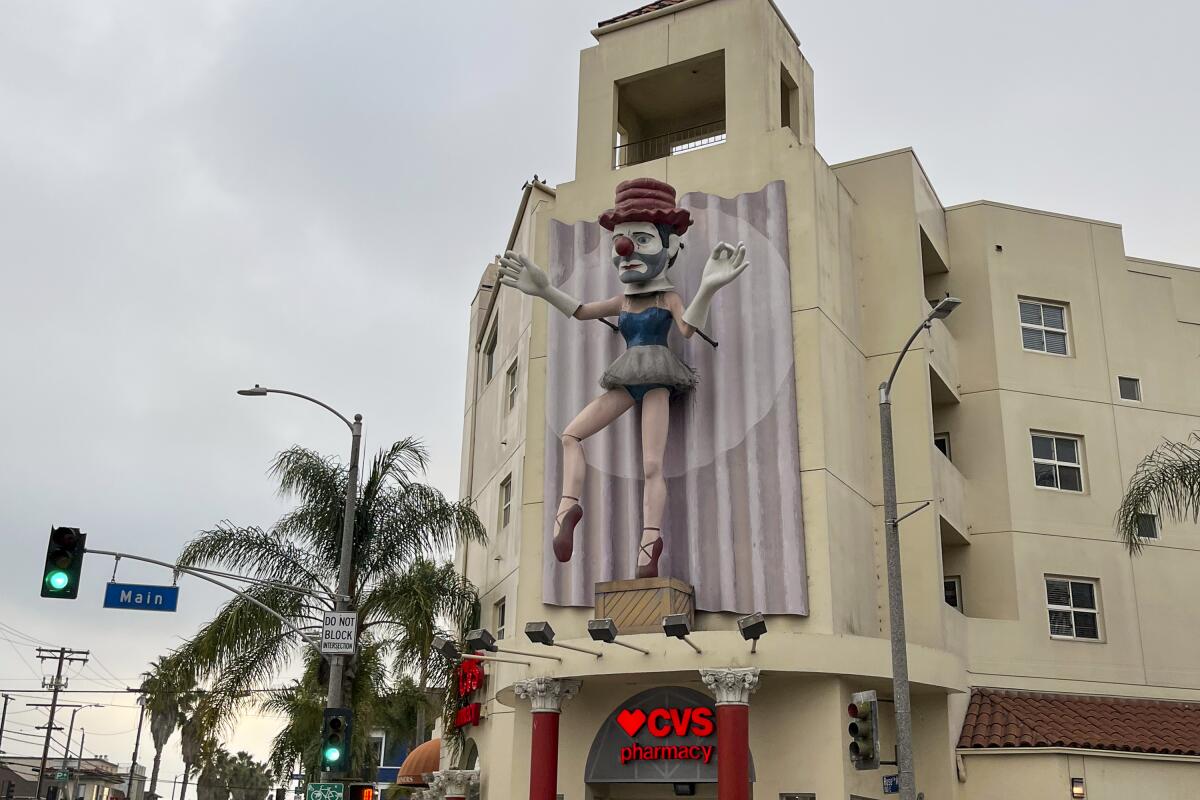 A clown ballerina sculpture on the side of a building