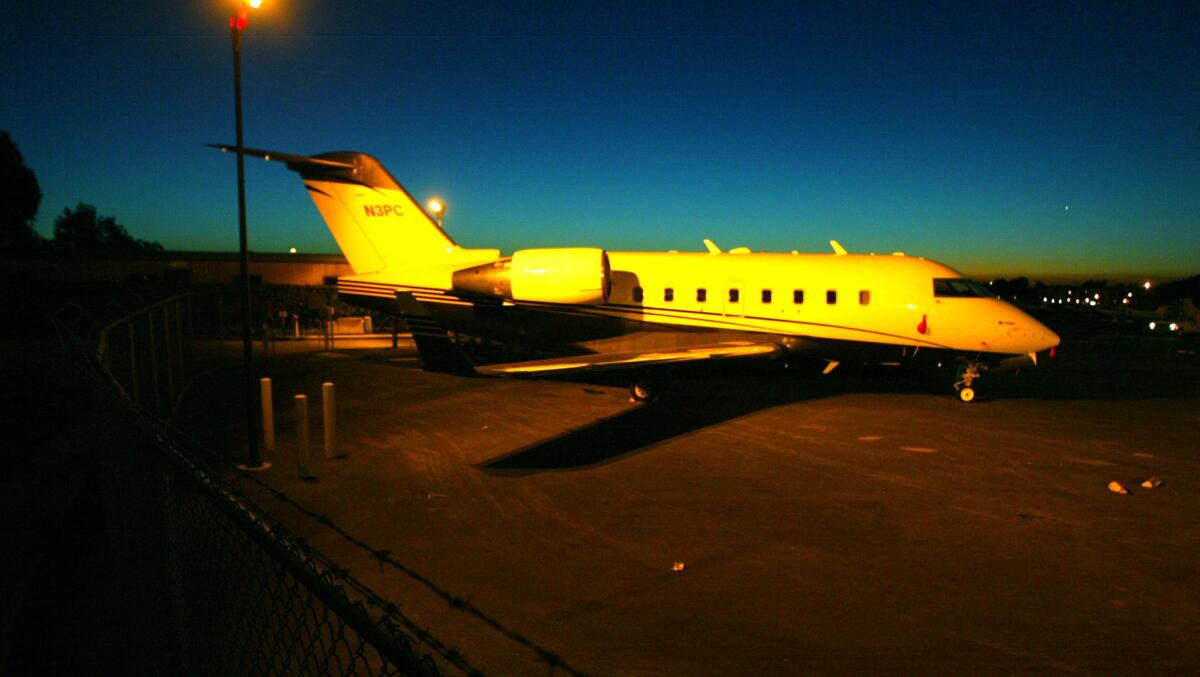 Sitting in the yellow glow of an industrial light in the corner of John Wayne Airport off Campus Avenue, and clearly visible to the public is a private jet believed to be owned by the Trinity Broadcasting Network (Mark Boster / Los Angeles Times)