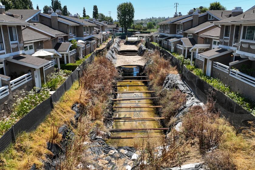 LaHabra Heights, CA, Wednesday, August 2, 2023 - An exposed flood channel bifurcates the Coyote Village condo complex, creating years of headaches for residents. (Robert Gauthier/Los Angeles Times)