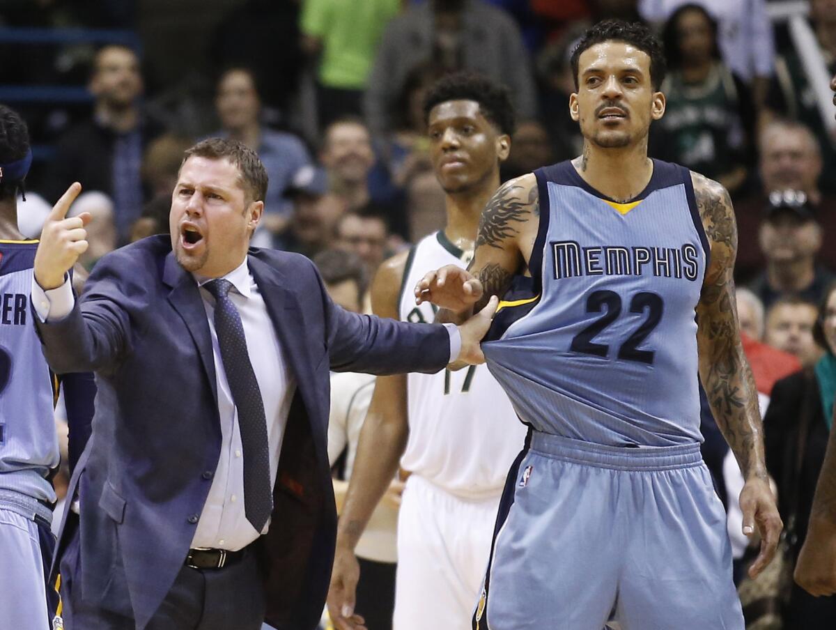 Grizzlies Coach David Joerger holds back Matt Barnes (22) after a double technical was called on Joerger and Milwaukee's John Henson during the second half of a game on March 17.