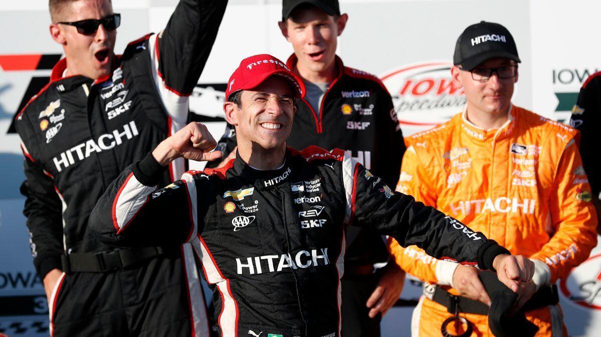 Helio Castroneves celebrates in Victory Lane after winning a IndyCar Series auto race on Sunday.
