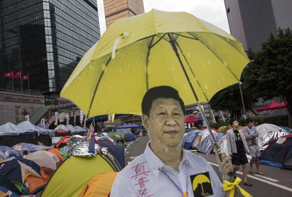 A cardboard cut-out of Chinese President Xi Jinping holding a yellow umbrella, the symbol of Hong Kong's pro-democracy movement, is seen outside a tent used by protesters in the territory's Admiralty neighborhood on Nov. 13.
