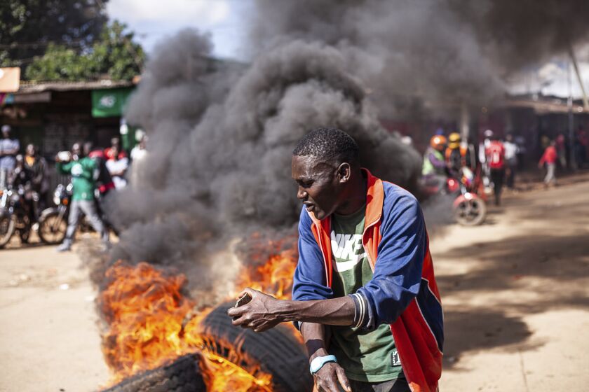 A protesters reacts next to a burning barricade during a mass rally called by the opposition leader Raila Odinga over the high cost of living in Kibera Slums, in Nairobi, Monday, March 27, 2023. Police in Kenya are on high alert ahead of the second round of anti-government protests organized by the opposition that has been termed as illegal by the government. Police chief Japheth Koome insists that Monday's protests are illegal but the opposition leader Raila Odinga says Kenyans have a right to demonstrate. (AP Photo/Samson Otieno)
