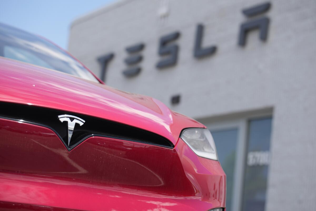 ARCHIVO - Un vehículo deportivo Model X se ve ante una tienda de Tesla