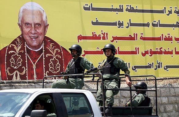 Palestinian security forces drive past a poster of Pope Benedict XVI near the Church of the Nativity in the West Bank town of Bethlehem.
