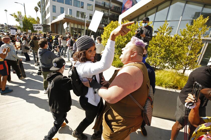 LOS ANGELES, CA - OCTOBER 20: Eureka O'Hara, right, and Blossom C. Brown, left, pull back after confronting free speech supporters as Netflix employees, activists, public figures and supporters gathered outside a Netflix location at 1341 Vine St in Hollywood Wednesday morning in support as members of the Netflix employee resource group Trans*, coworkers and other allies staged a walkout to protest Netflix's decision to release Dave Chappelle's latest Netflix special, which contains a litany of transphobic material. Hollywood on Wednesday, Oct. 20, 2021 in Los Angeles, CA. (Al Seib / Los Angeles Times).