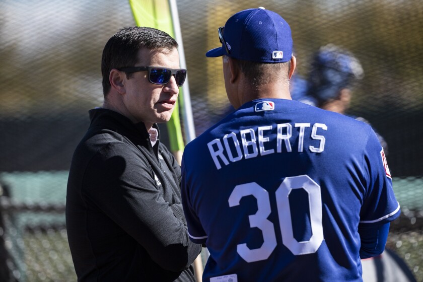 Dodgers President of Baseball Operations Andrew Friedman speaks with manager Dave Roberts.